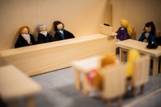 Modellierter Gerichtssaal mit Holzpuppen als Richter